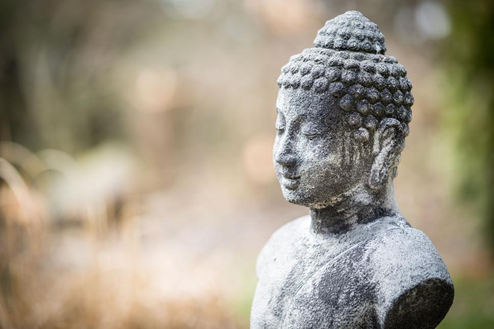 Free Image of Stone statue of a serene figure in garden setting 