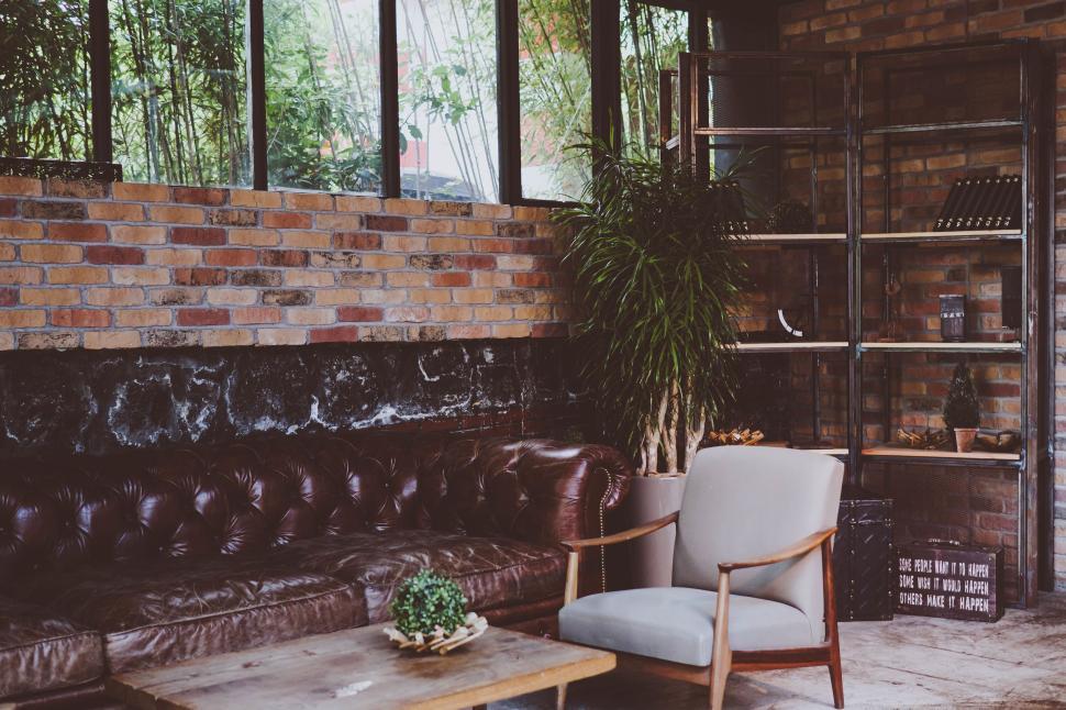 Free Image of Cozy lounge area with brick walls and large windows 