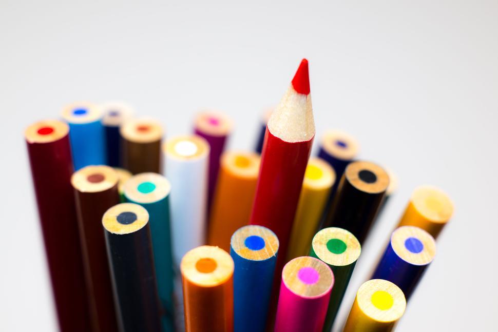 Free Image of Colorful pencils gathered with one red pencil upright. 