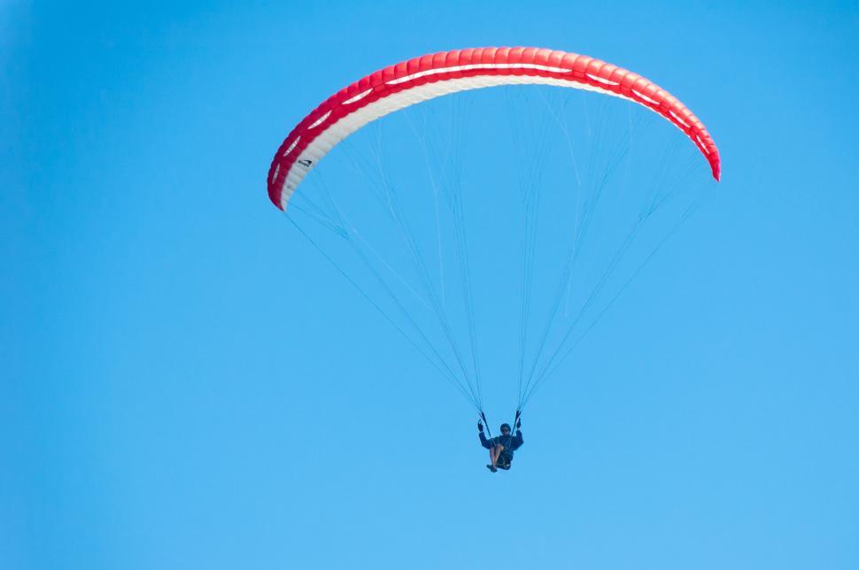 Free Image of Paraglider gliding through the clear blue sky. 