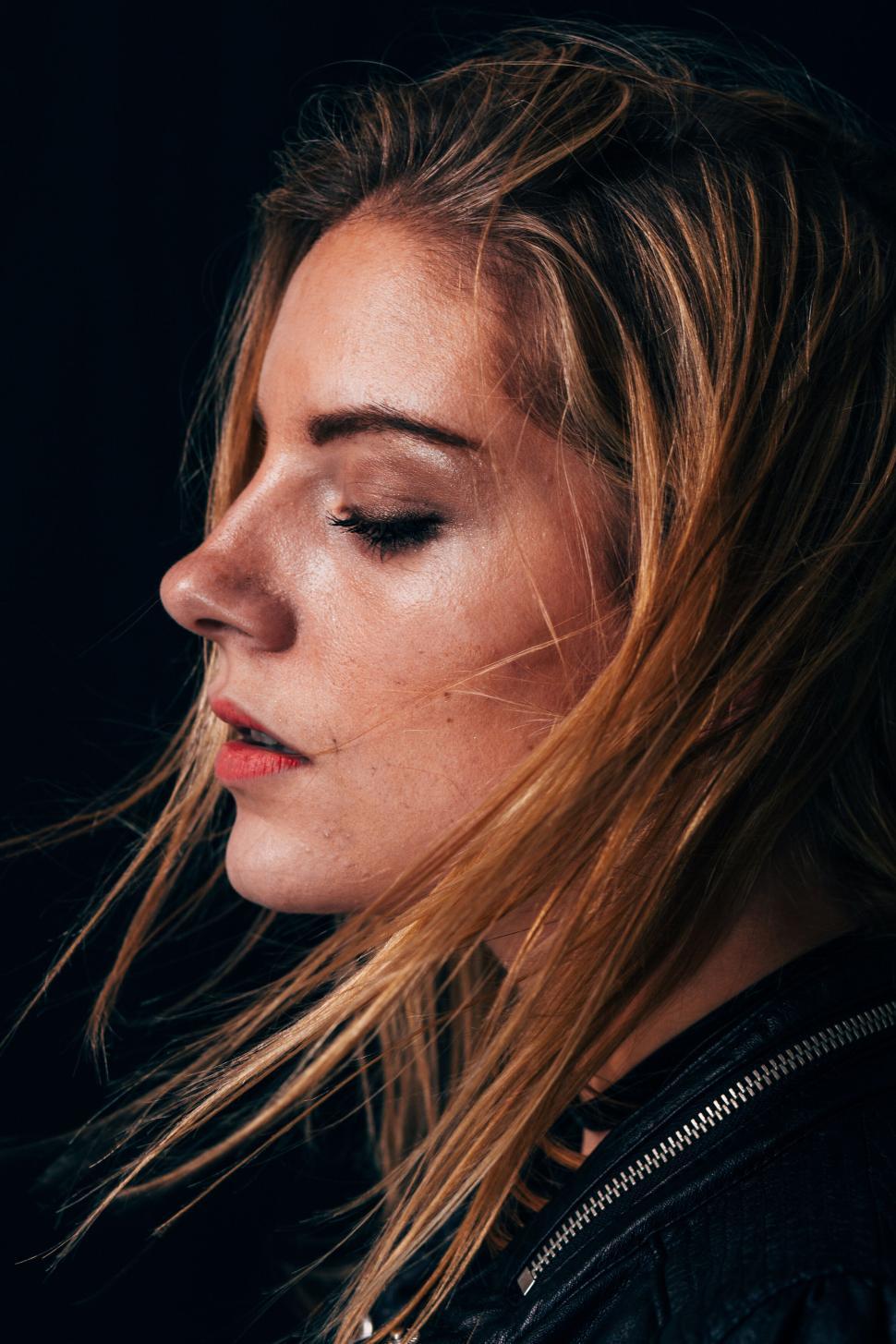 Free Image of Profile of woman with closed eyes and wind-swept hair 