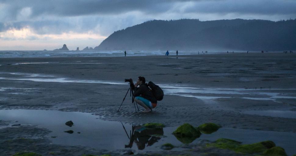 Free Image of Photographer capturing the coastal landscape at dusk 