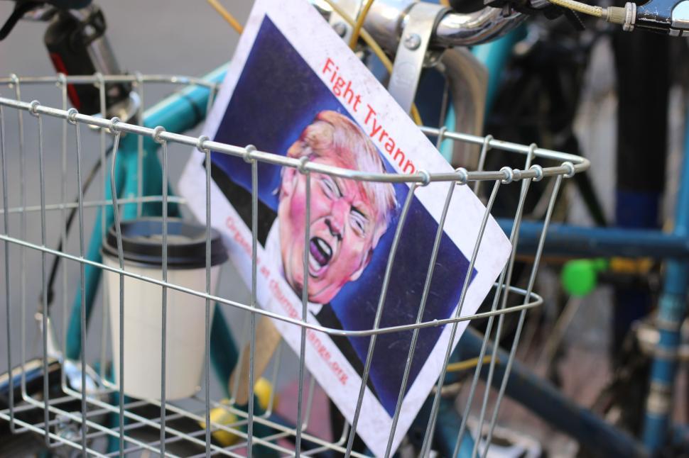 Free Image of Bicycle with sign in basket and coffee cup in basket. 