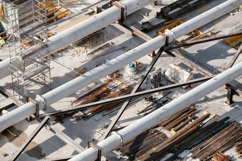 Free Image of Construction site with large pipes and scattered materials 