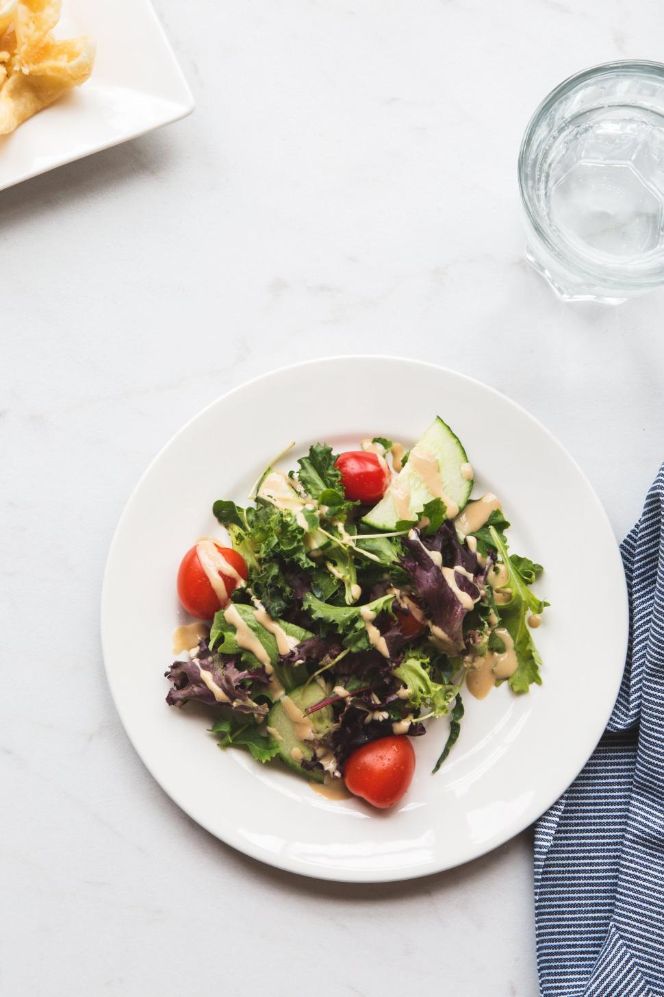 Free Image of Fresh vegetable salad served on a white tablecloth. 