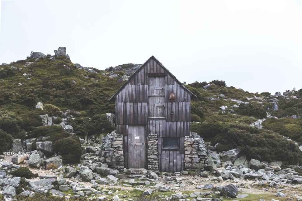Free Image of Rustic wooden cabin in a rocky mountain landscape 