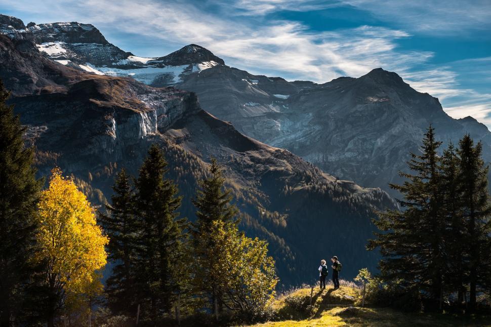 Free Image of Hikers in scenic mountain landscape with snow-capped peaks. 