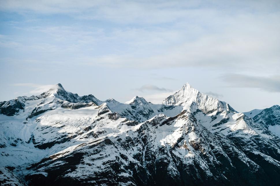 Free Image of Snow-capped mountain peaks under clear blue sky 
