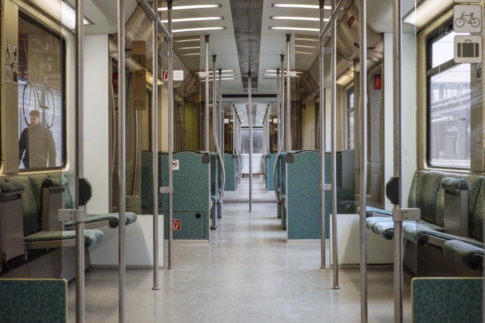 Free Image of Empty subway train interior with seats and steel poles 
