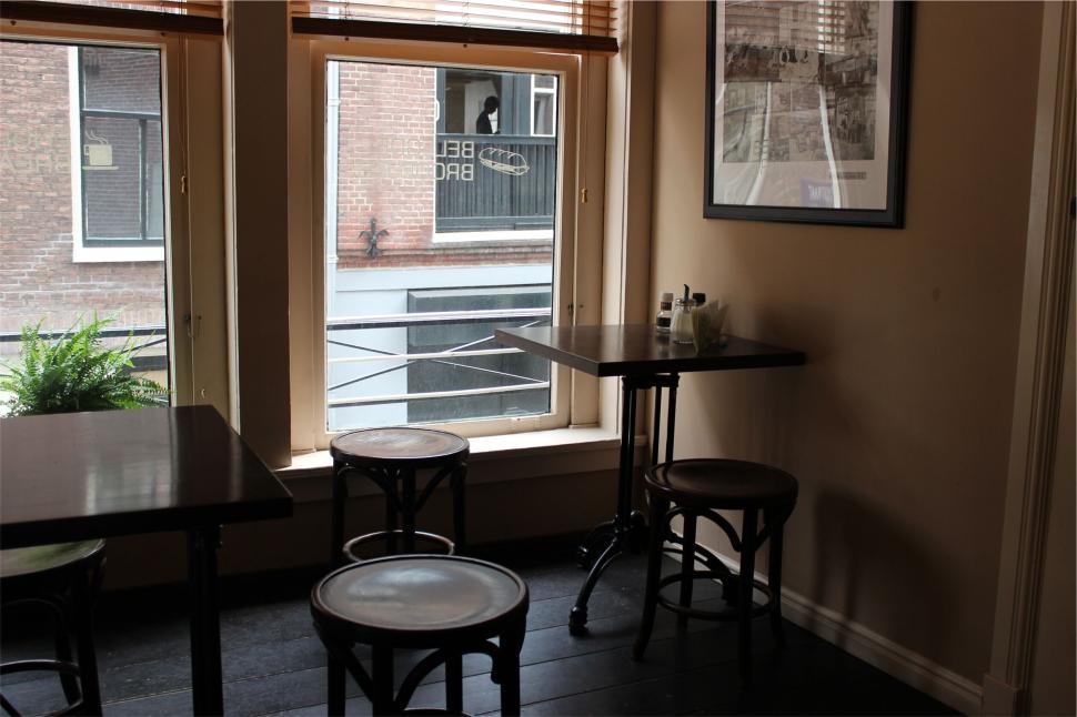 Free Image of Cafe interior with empty chairs and tables by window. 