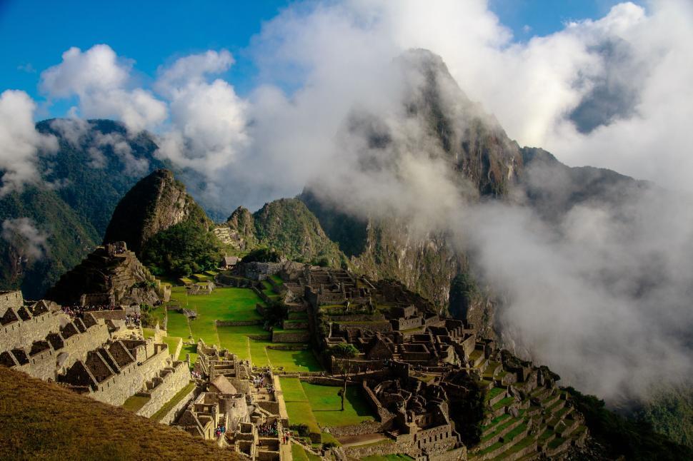 Free Image of Ancient stone city ruins amidst mountain mist and clouds 