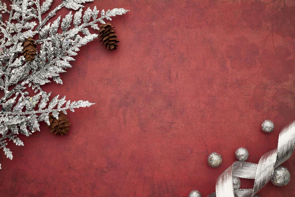 Free Image of Frosted pinecones and silver branches on red backdrop 