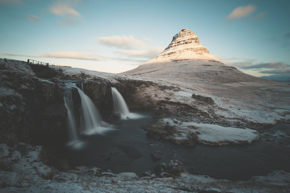 Free Image of Icy mountain with cascading waterfalls in foreground 