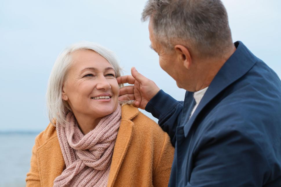 Free Image of Older couple in warm clothes enjoying beach together. 