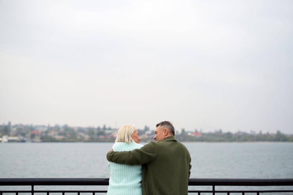 Free Image of Elderly couple embracing by water, enjoying view 