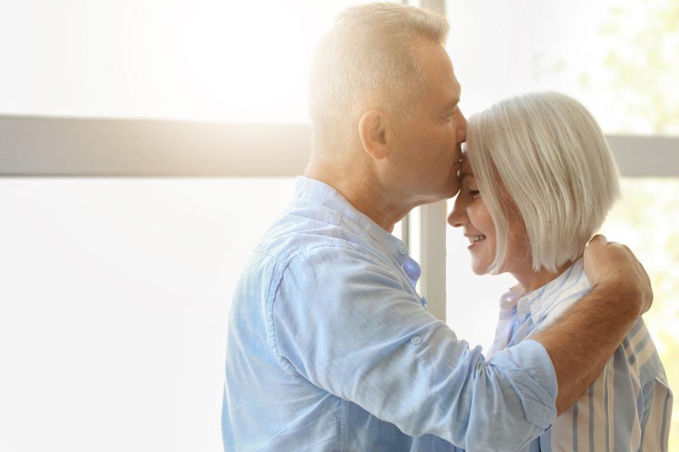 Free Image of Couple Sharing an Intimate Moment by the Bright Window Light 