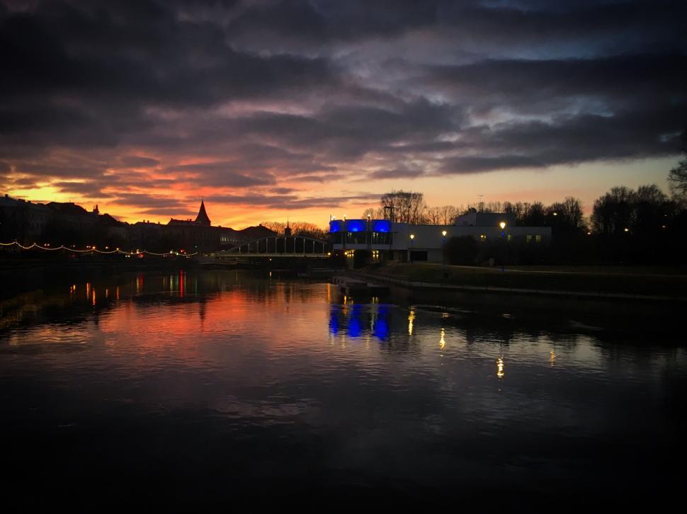 Free Image of Sunset reflecting on a calm river with cloudy sky 