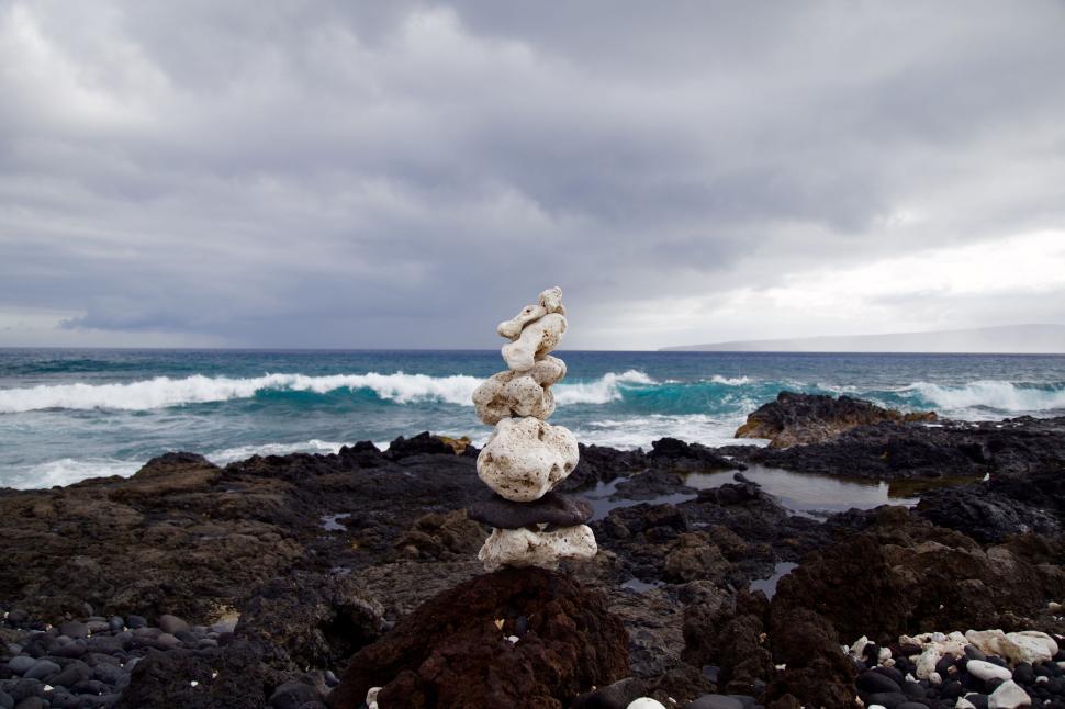 Free Image of Balanced rock formation on a rocky shore with waves. 