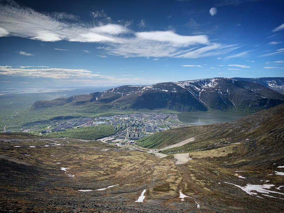 Free Image of Overlooking a town nestled in mountains, clear horizon. 