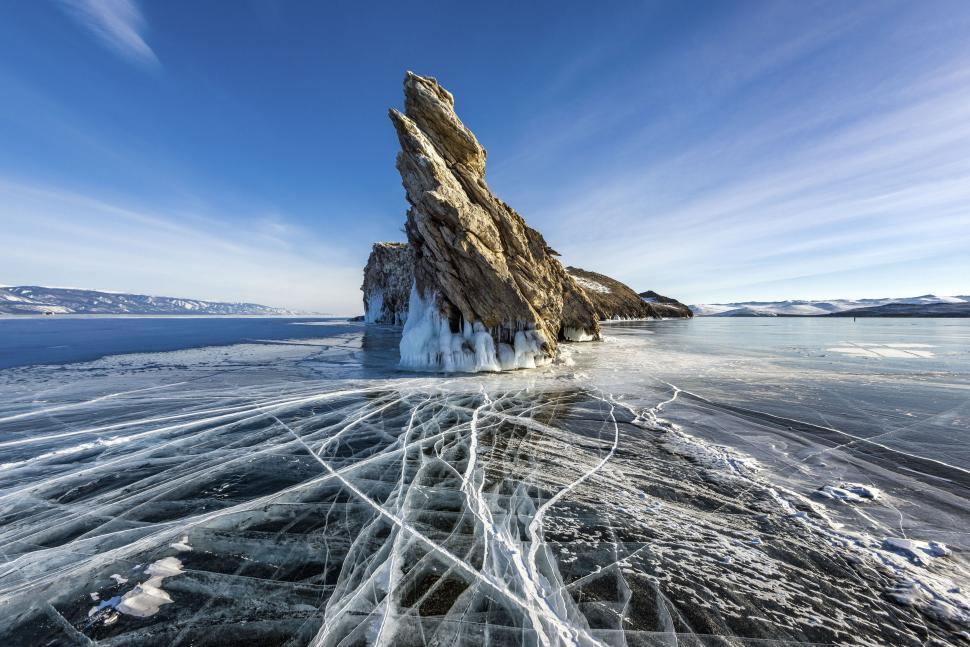 Free Image of Ice-covered rock formation on a frozen lake landscape 