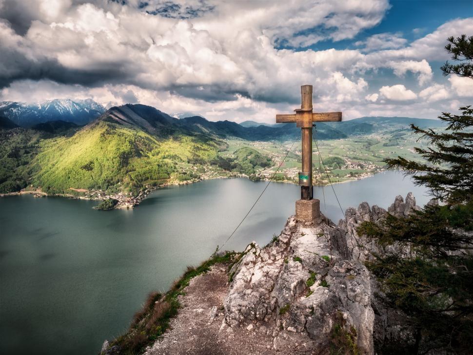 Free Image of Hilltop cross with a panoramic view over a calm lake. 