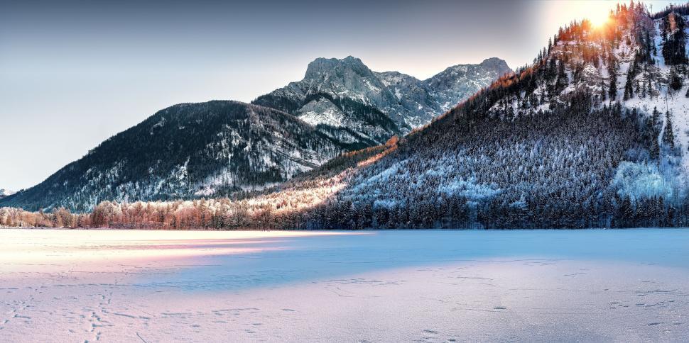 Free Image of Mountain peaks surrounding a wintery frozen lake 