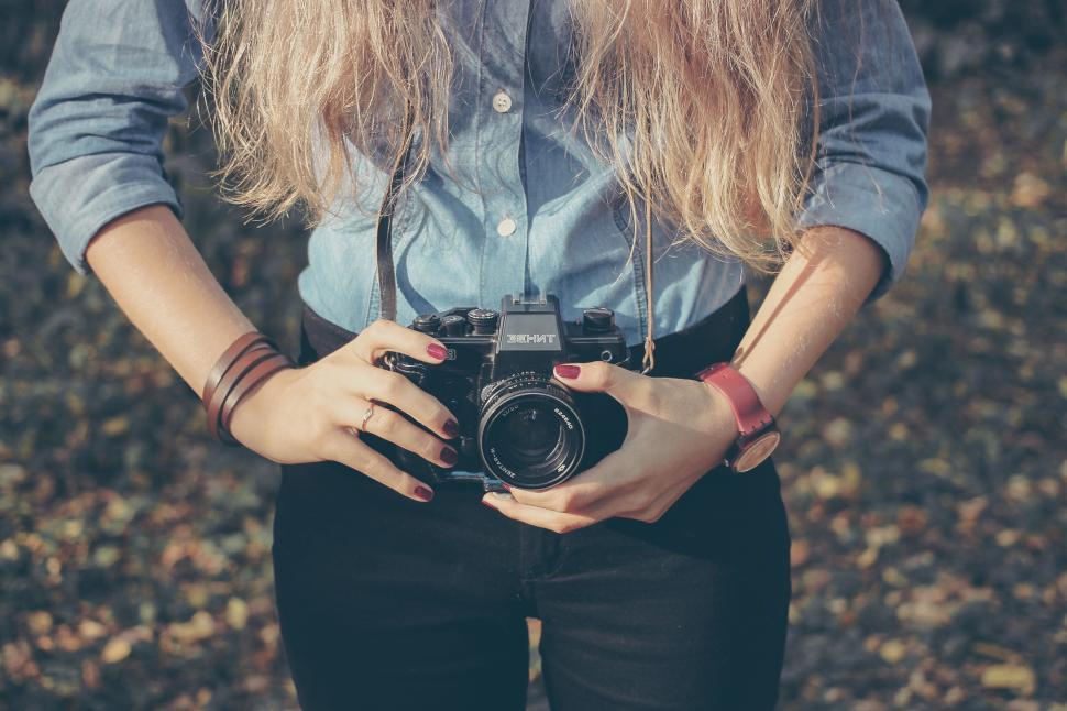 Free Image of Woman holding a camera ready for photography 