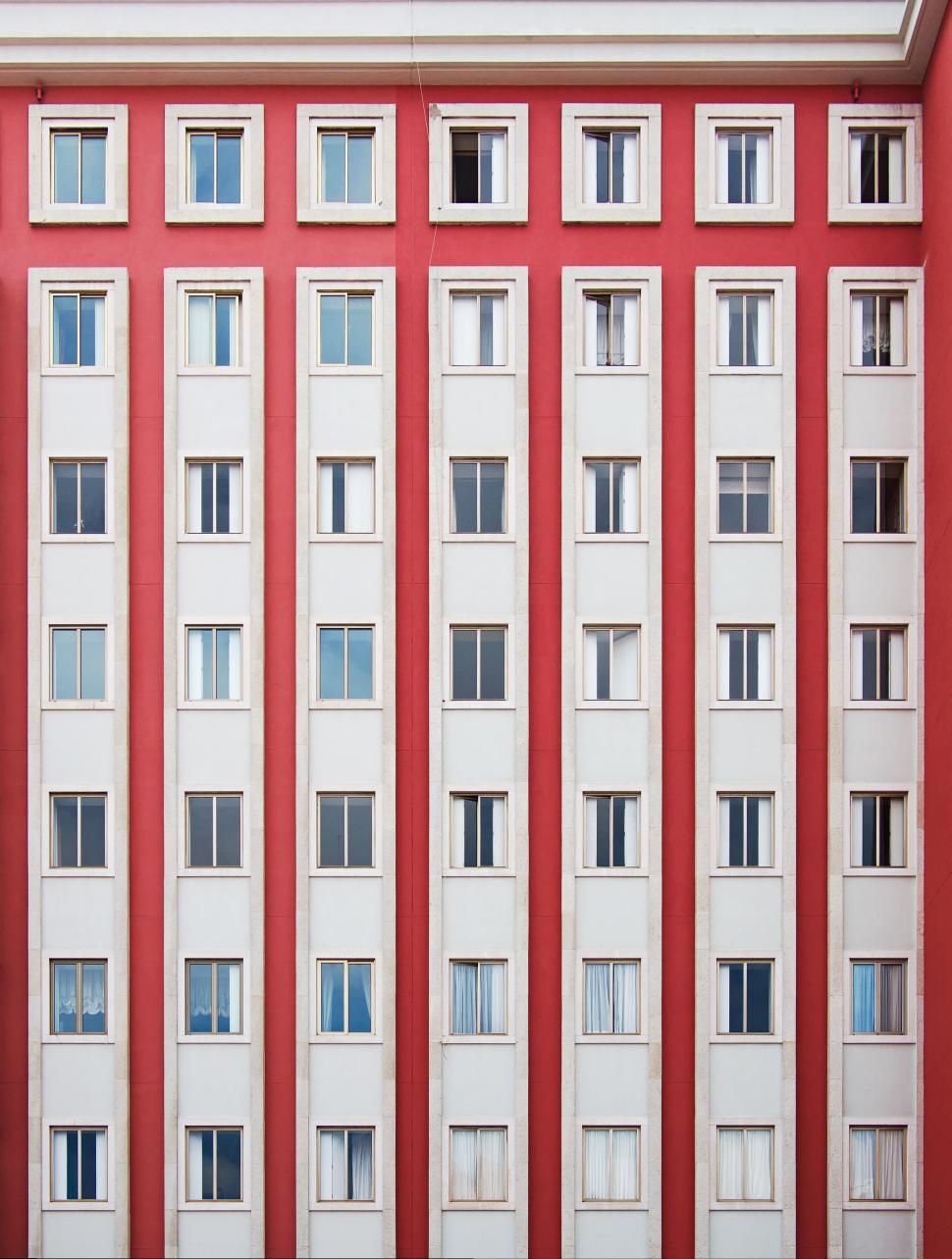 Free Image of Symmetrical building with multiple windows painted in red 