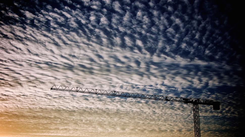 Free Image of Construction crane under a sky filled with clouds. 