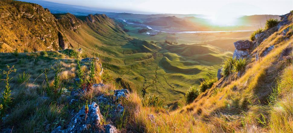 Free Image of Panoramic view of green valleys and cliffs at sunrise 
