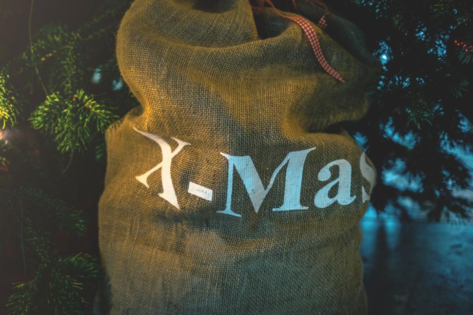 Free Image of Hessian sack with X-Mas text under Christmas tree 