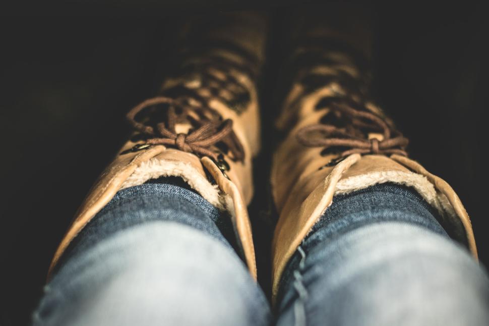 Free Image of Close-up of tan winter boots with denim jeans outfit 