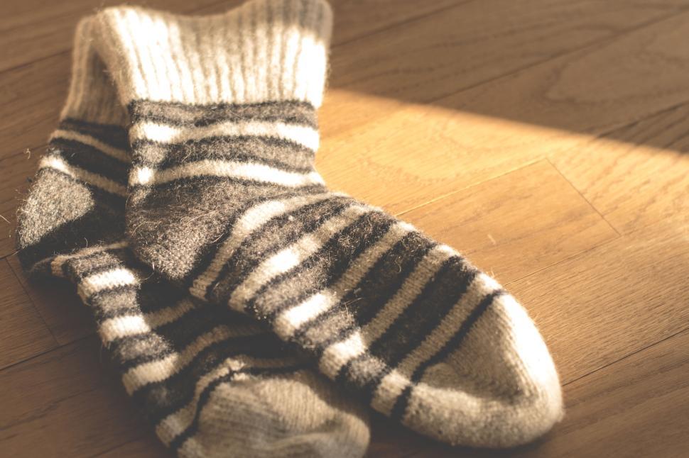 Free Image of Warm woolen socks with black stripes on wooden floor 