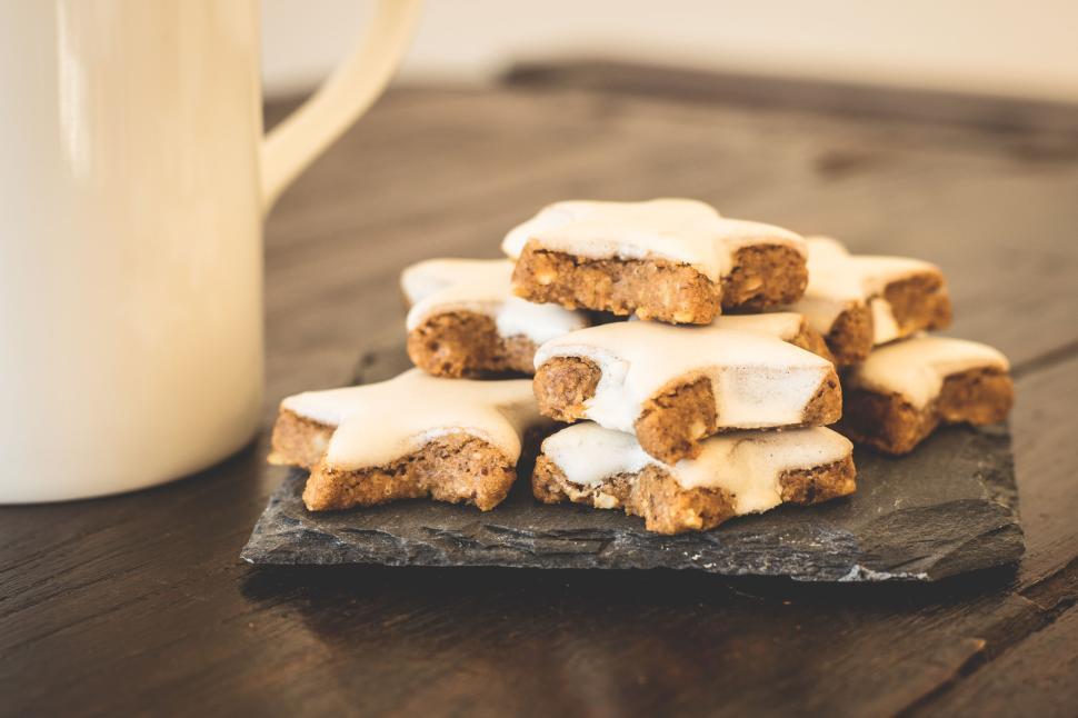 Free Image of Star-shaped cookies on slate plate next to coffee mug 