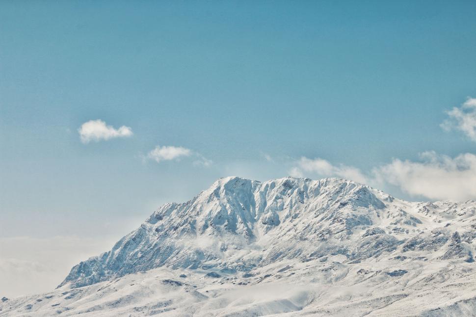 Free Image of Snow-covered mountain peak under clear blue sky. 