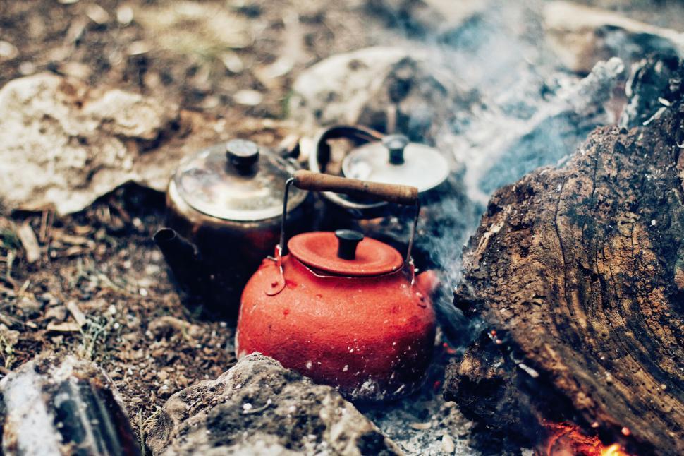 Free Image of Kettles and pots heating on a campfire for meal prep 