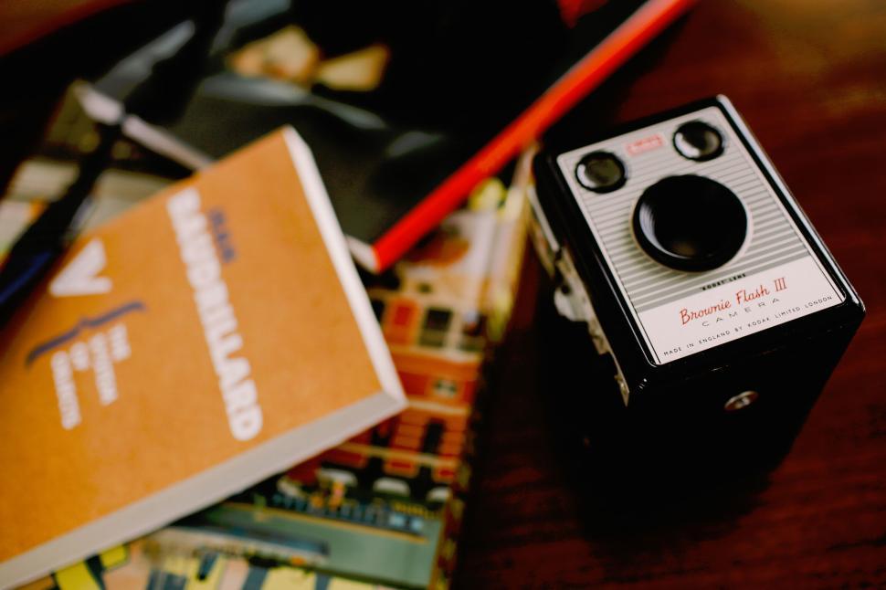 Free Image of Vintage camera and books on a wooden table. 