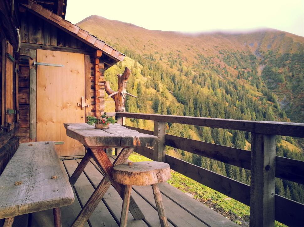 Free Image of Mountain cabin porch with wooden table and benches 