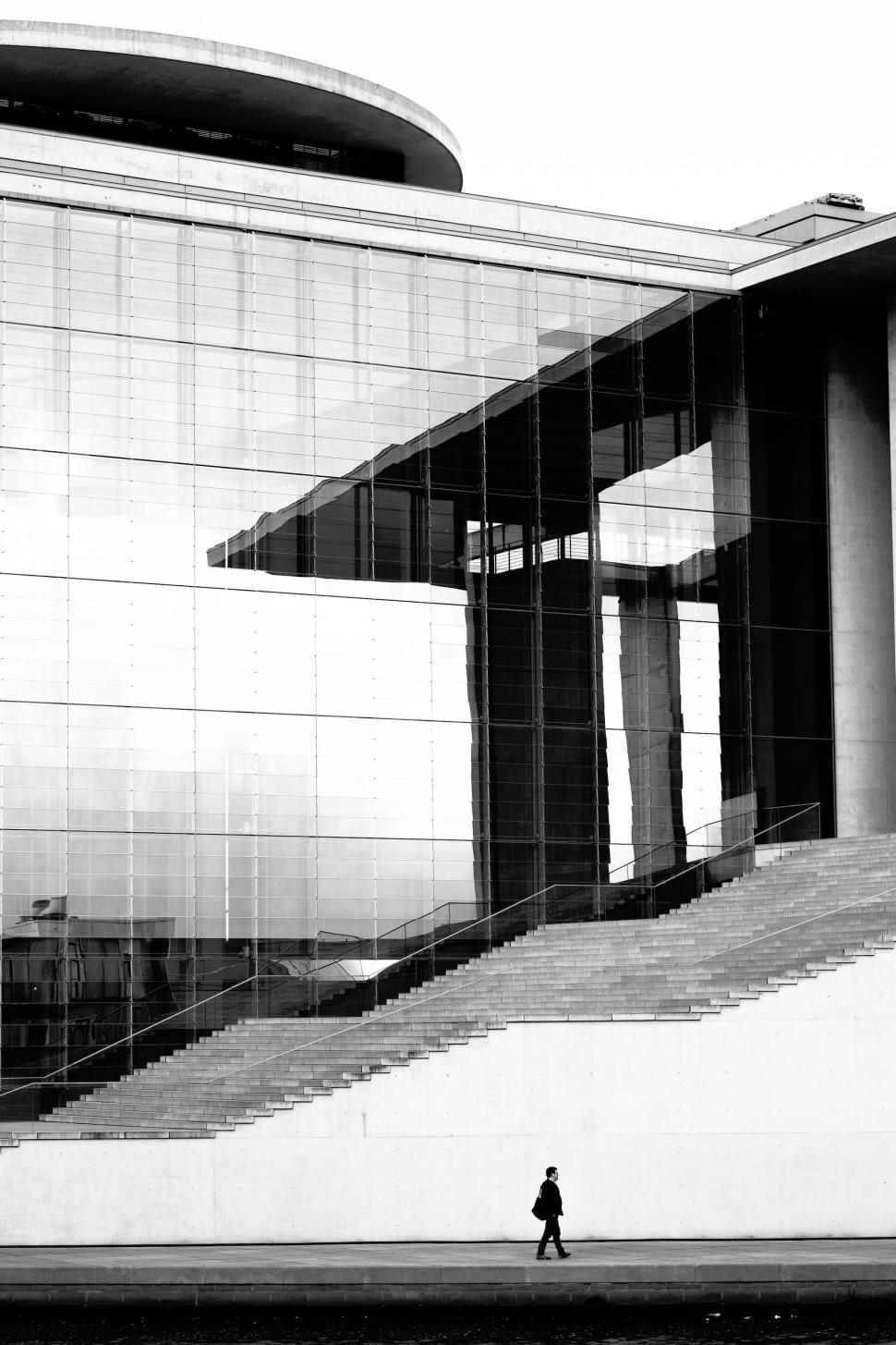 Free Image of Architectural building with glass facade and lone figure 