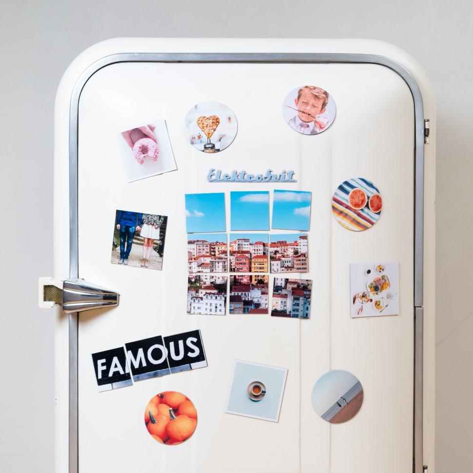 Free Image of White fridge door with colorful magnets and photos 