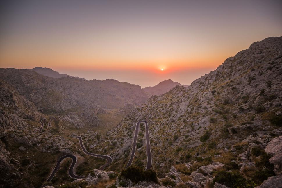Free Image of Winding mountain road with a scenic sunset view 