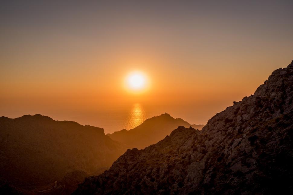 Free Image of Golden sunset over rugged mountain landscape and sea 
