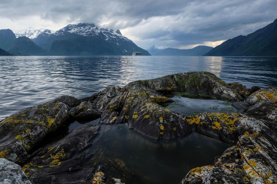 Free Image of Serene mountain lake view with rocky shoreline panorama. 