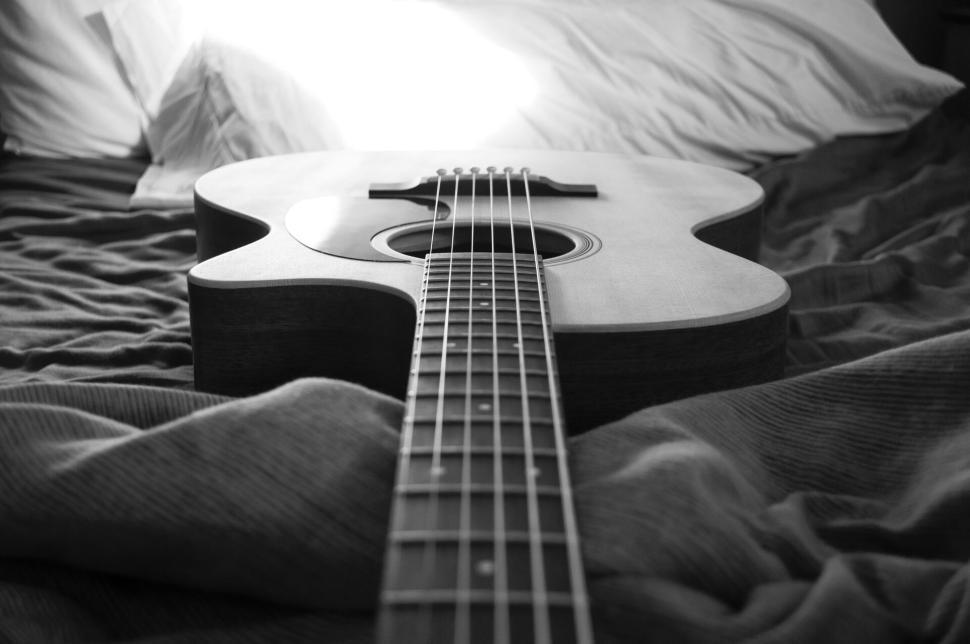 acoustic-guitar-lying-on-bed-with-soft-lighting..jpg