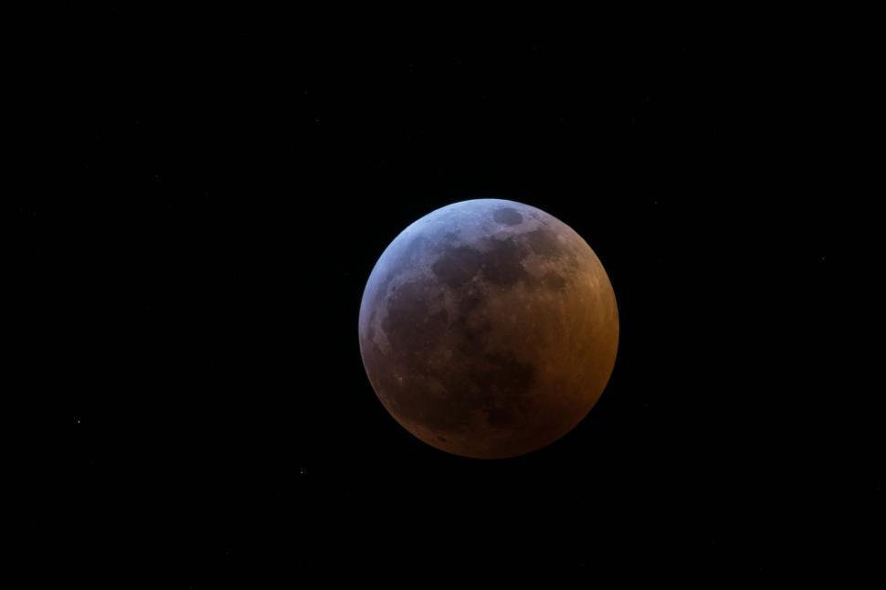 Free Image of Eclipsed moon glowing against a dark night sky. 