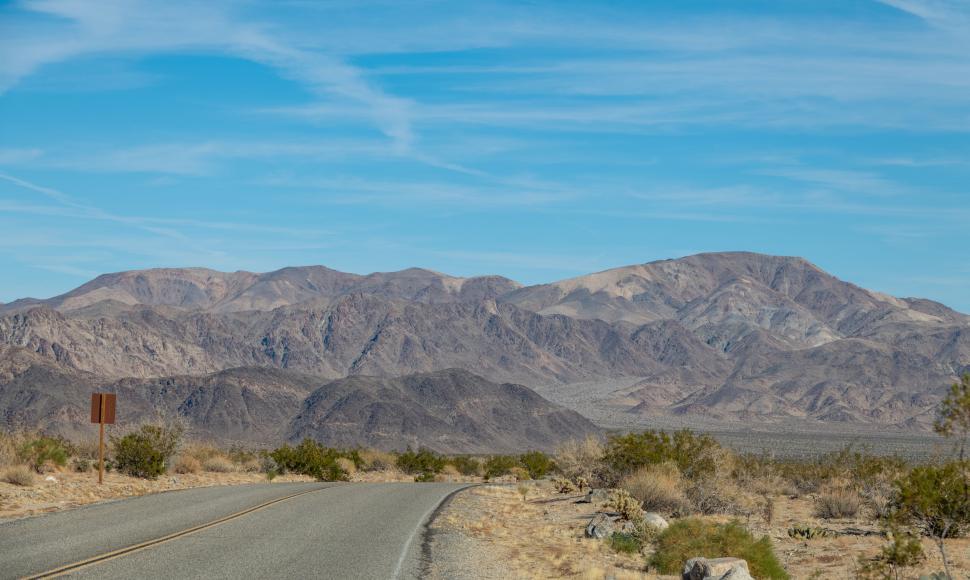Free Image of Desert road leading to distant mountain ranges 