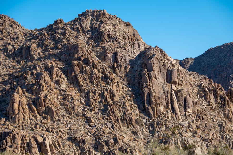Free Image of Rugged rocky desert landscape under clear blue sky. 