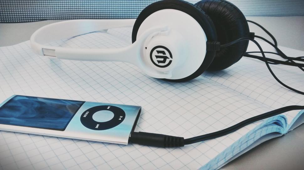 Free Image of Headphones and MP3 player on a graph paper notebook 