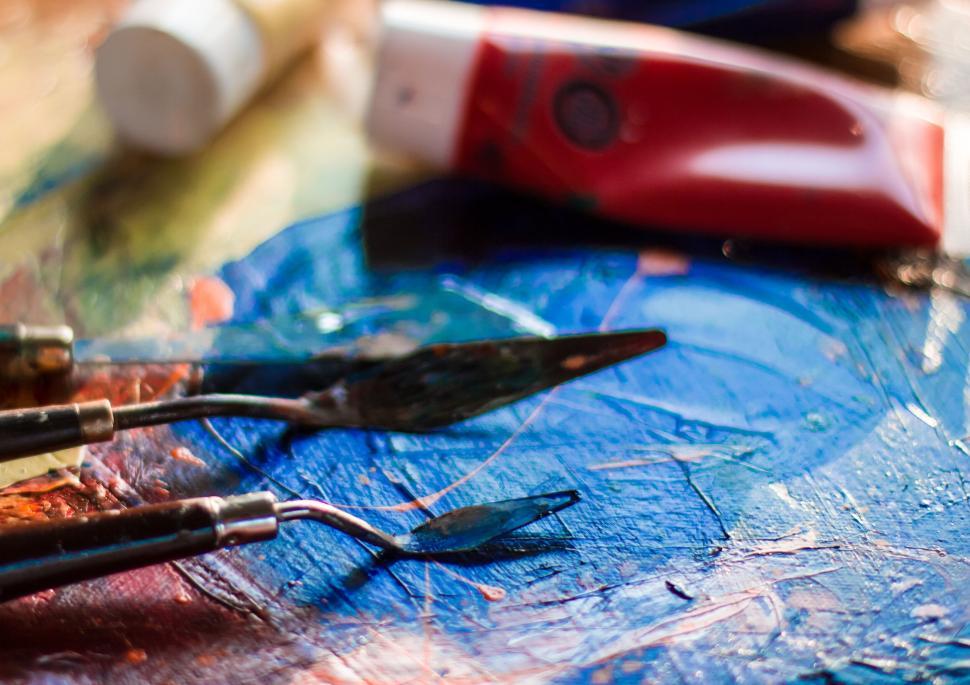 Free Image of Art supplies spread out on a palette with blue paint 