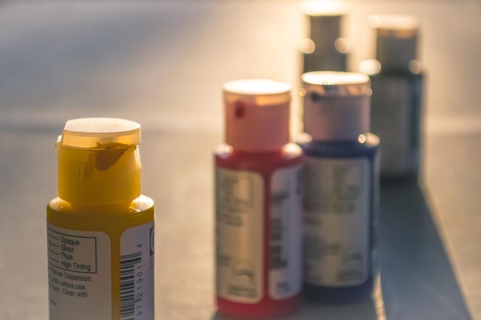 Free Image of Colorful acrylic paint bottles arranged on a surface. 